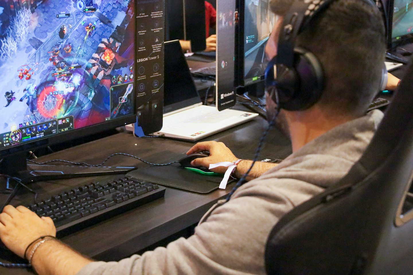 Gamer wearing headphones plays a fantasy video game on a monitor.